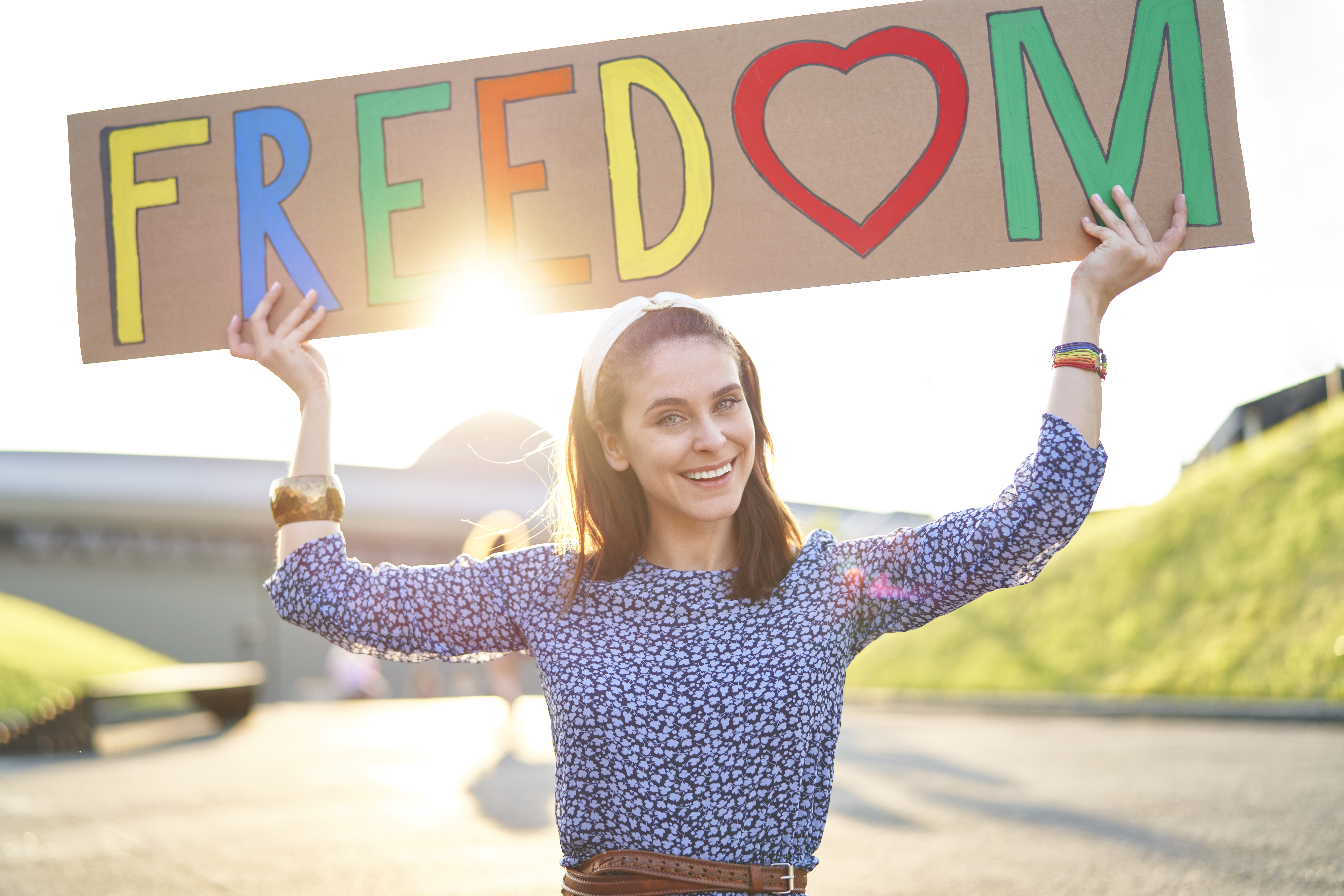 Beautiful smiling woman standing with a colored billboard