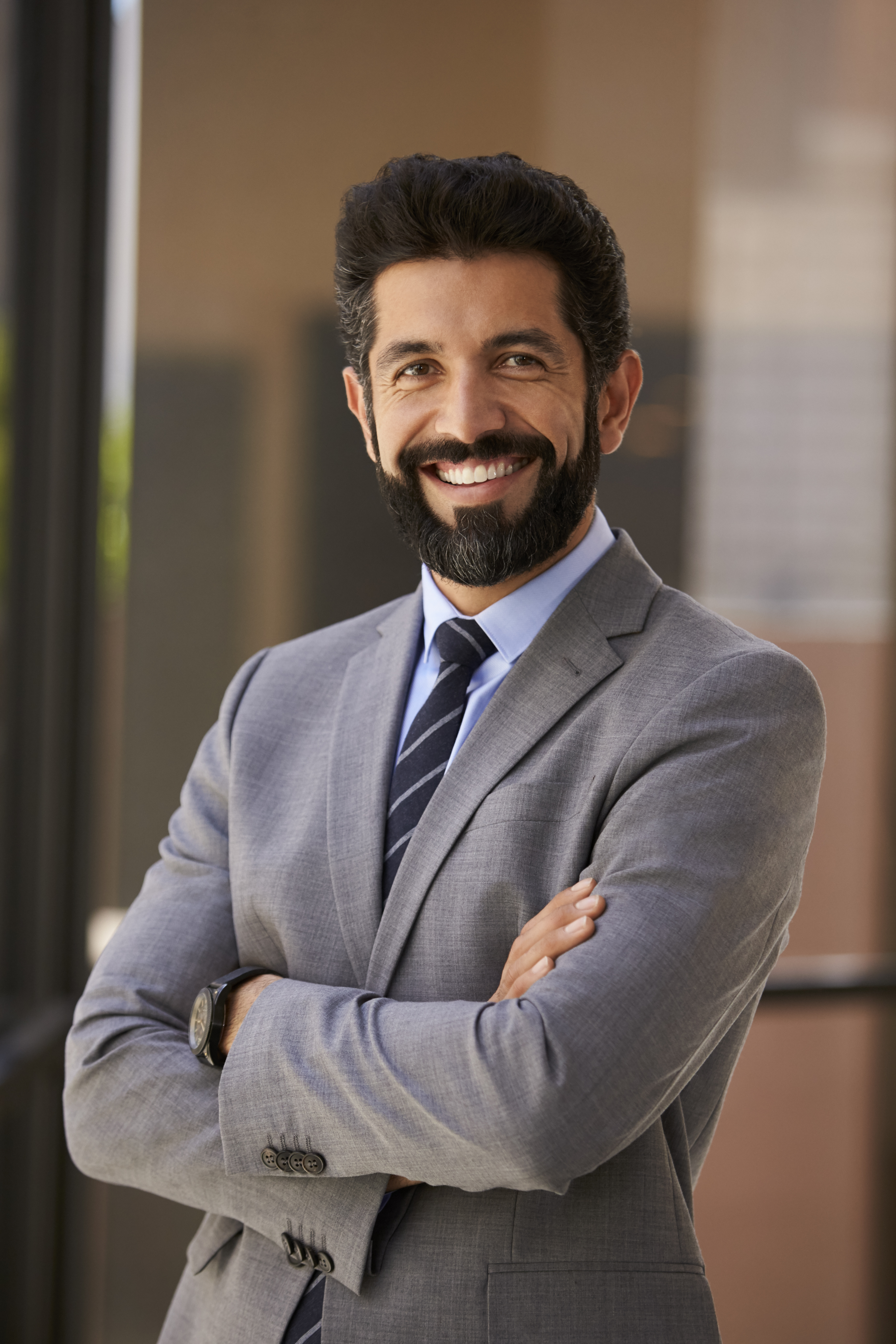 smiling-hispanic-businessman-with-arms-crossed-